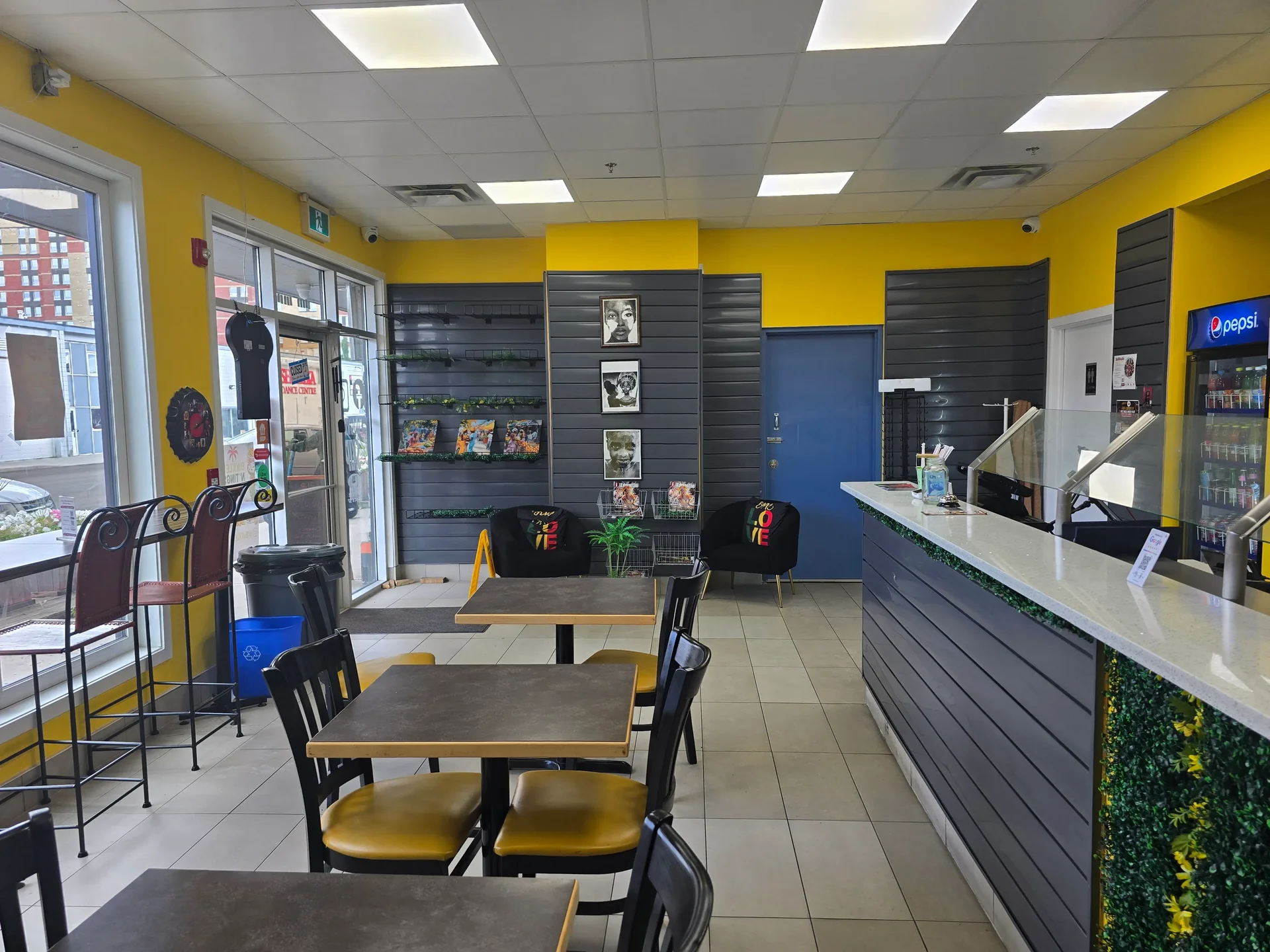 Dine-in tables and front counter inside Bikkles N’ Tings Caribbean Eatery in Edmonton, AB
